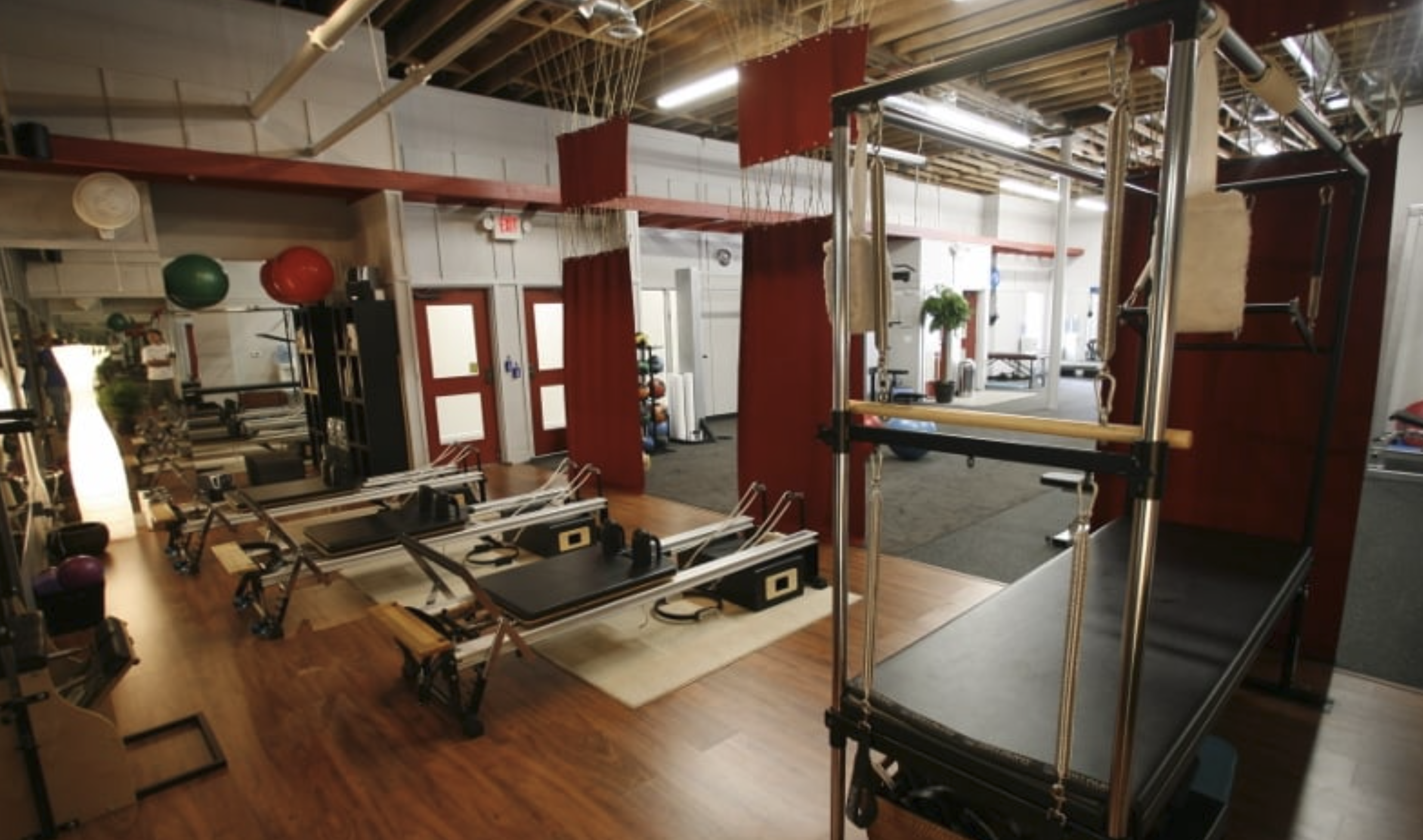Row of Pilates reformers and a tower unit on the pillarPERFORMANCE studio floor in Carlsbad California